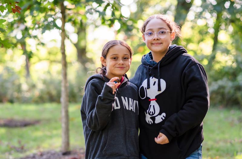 Two friends pose holding an acorn on a Brushwood field trip