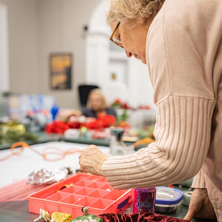 A woman sorting through a bin of beads for a project