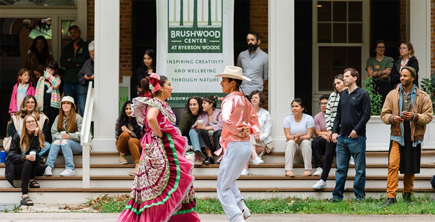 A couple doing a traditional dance in front of a crowd at the Visible Exhibition