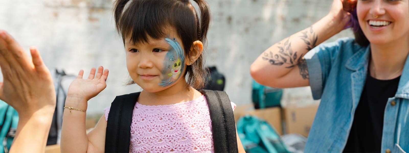 A young girl giving a high five after getting her explorer backpack from Brushwood