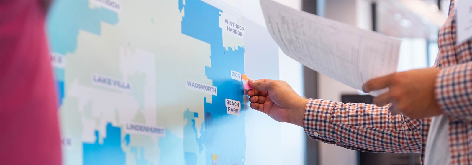 Participants add stickies to a map of northern Illinois during a community leadership roundtable