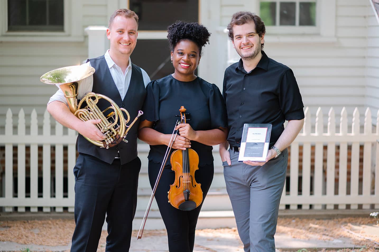 The Black Moon Trio with their instruments and an award