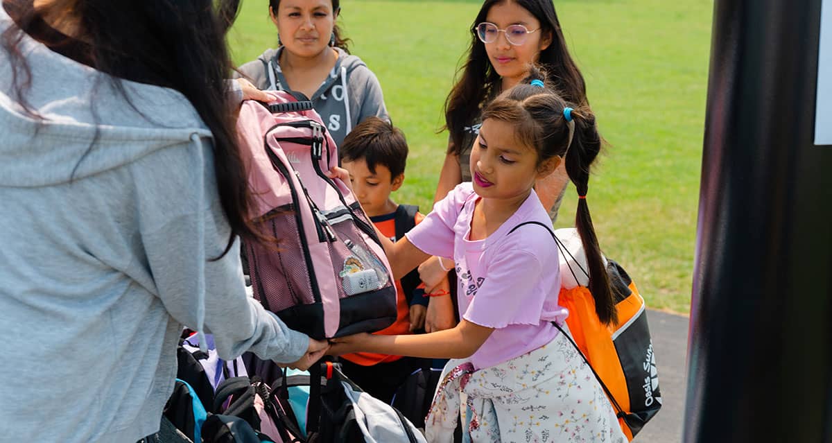 A young girl picks up her new Nature Explorer Backpack in Highwood