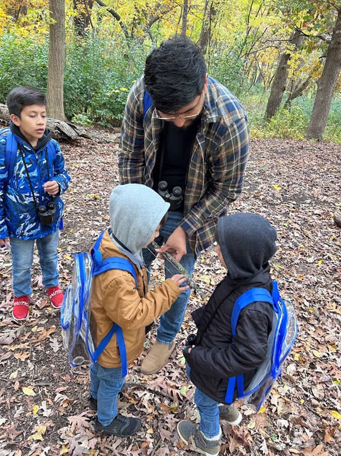 Eddie Flores and kids investigate a stick found on a nature hike