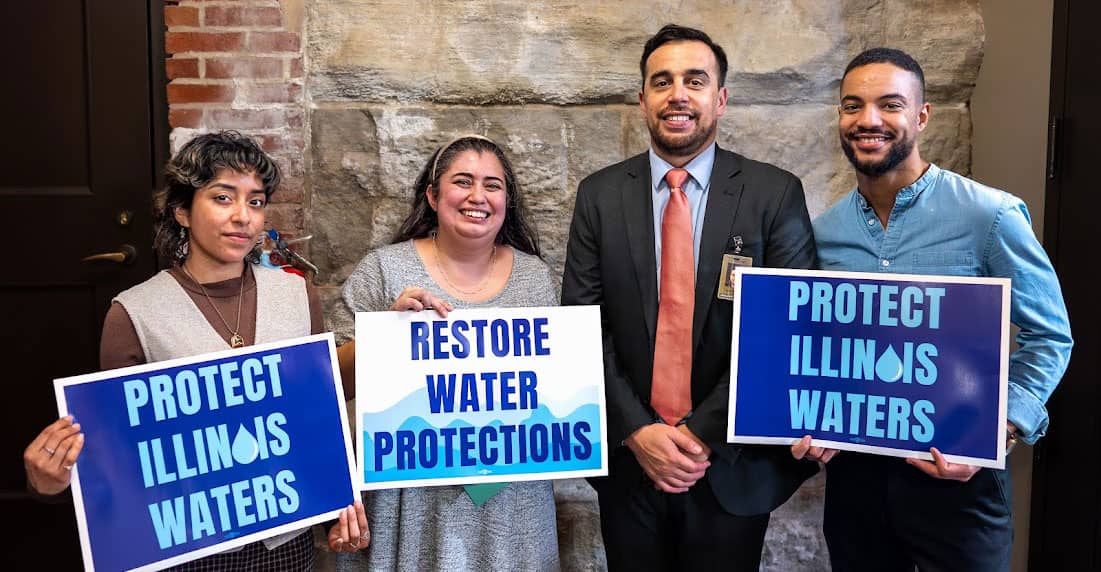 Organizers holding political signs reading 'Protect Illinois Waters' and 'Restore Water Protections'