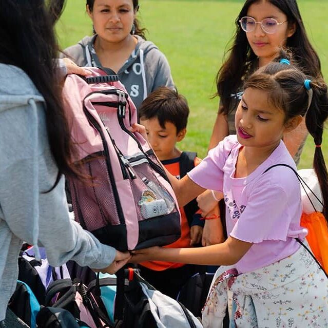 A young girl picks up her new Nature Explorer Backpack in Highwood