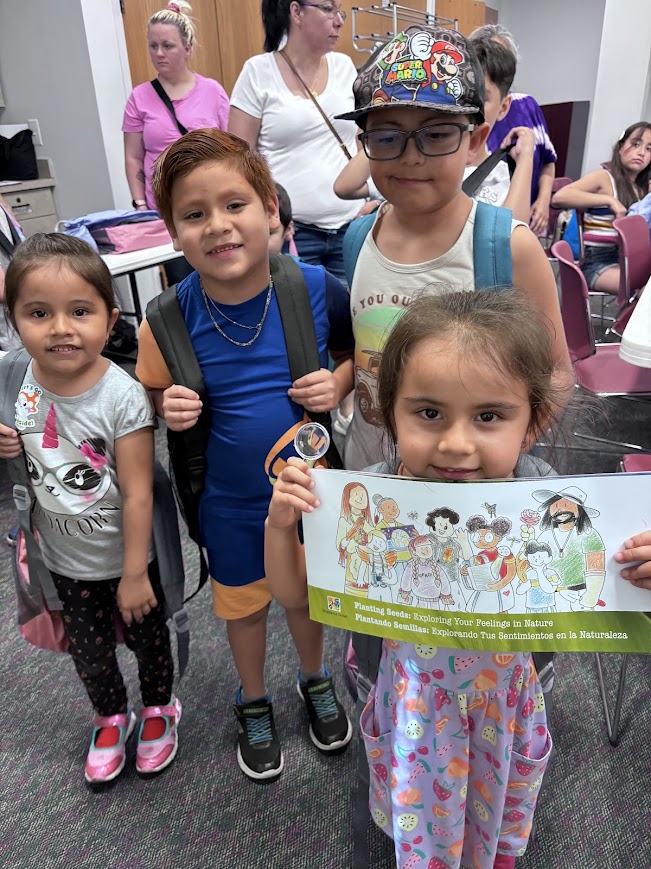 Children hold up Planting Seeds.