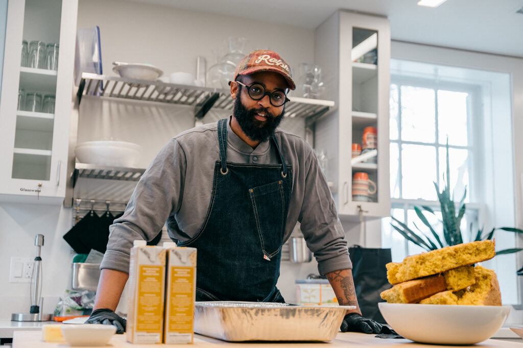 Jeffrey Williams in the Brushwood kitchen, with a large bowl of cornbread, ingredients, and a baking pan.