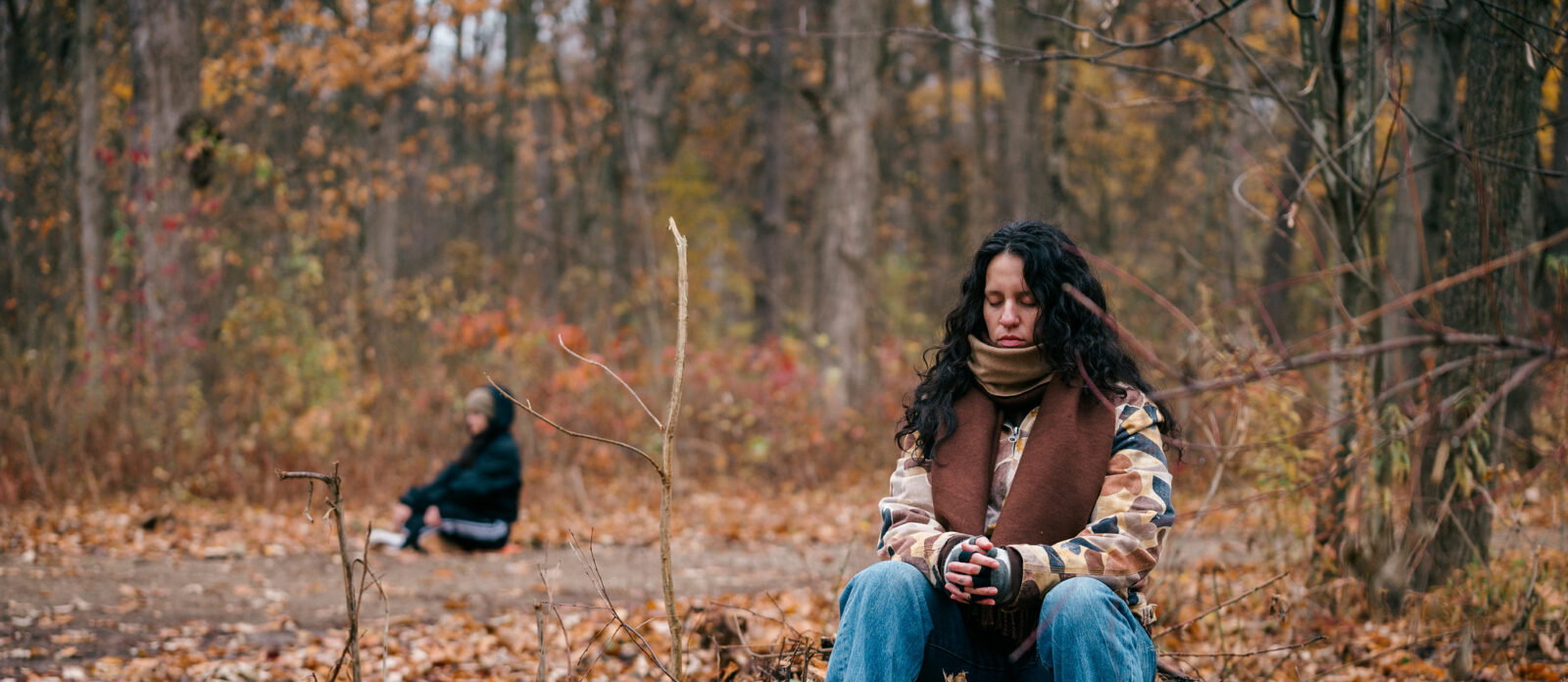 Person sits contemplatively in nature