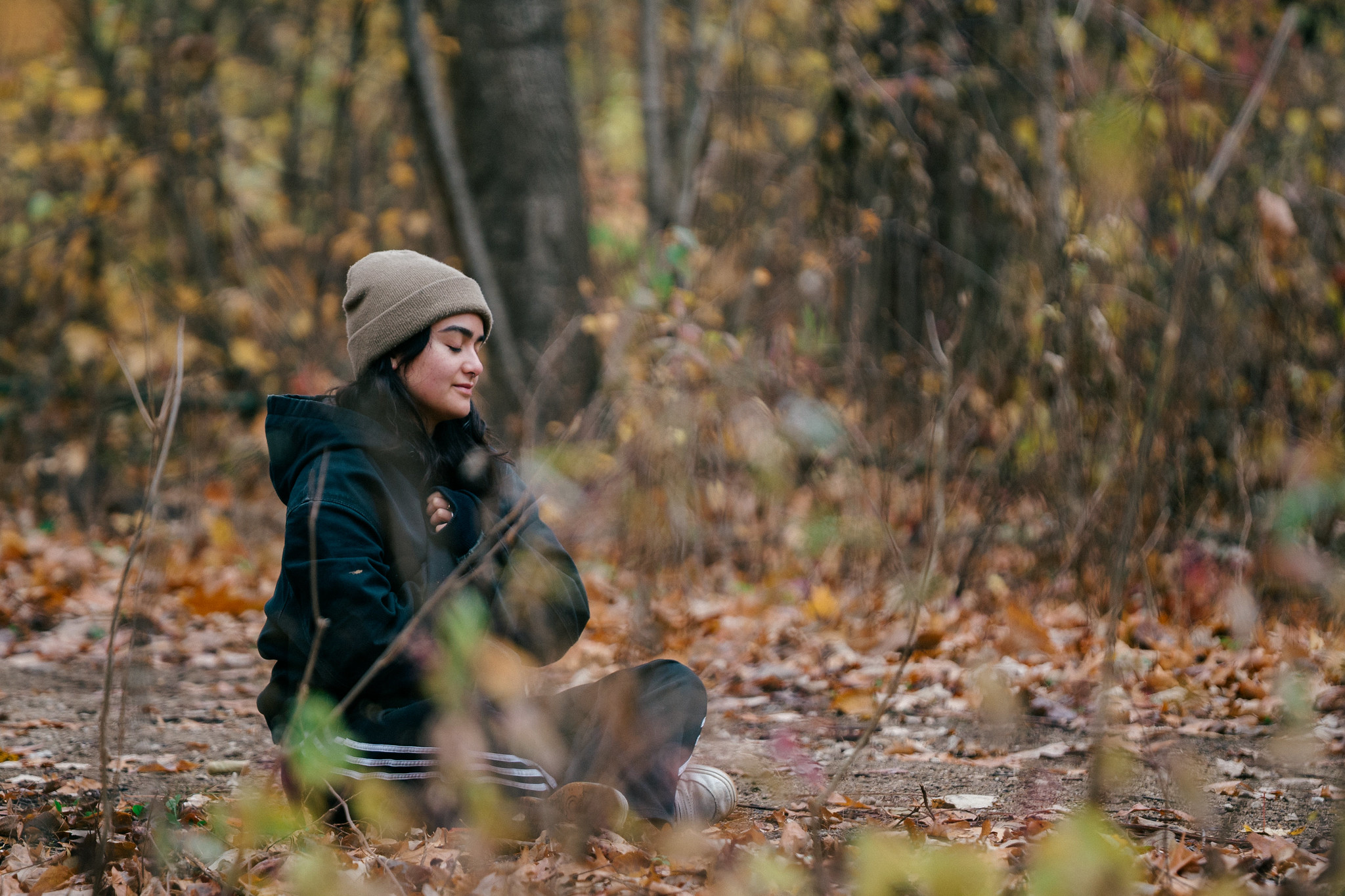 A person sits on the forest floor