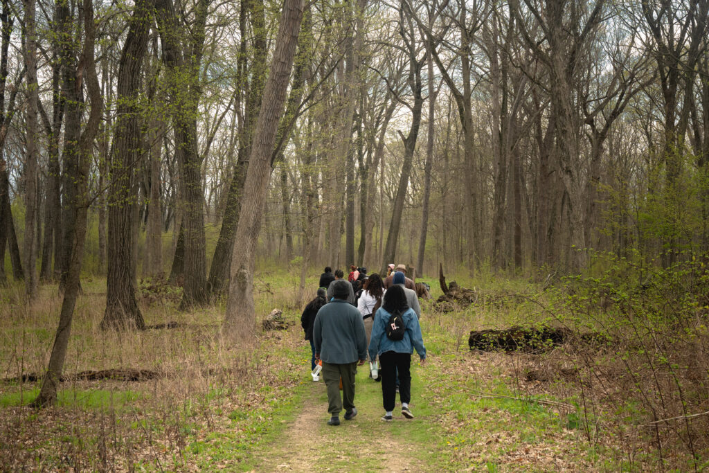 The group walks into Ryerson Woods in early spring. 
